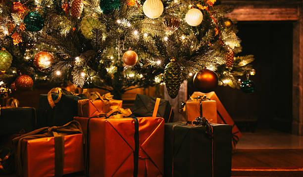 istock Wrapped gifts beneath glowing illuminated Christmas tree at night 2249703943