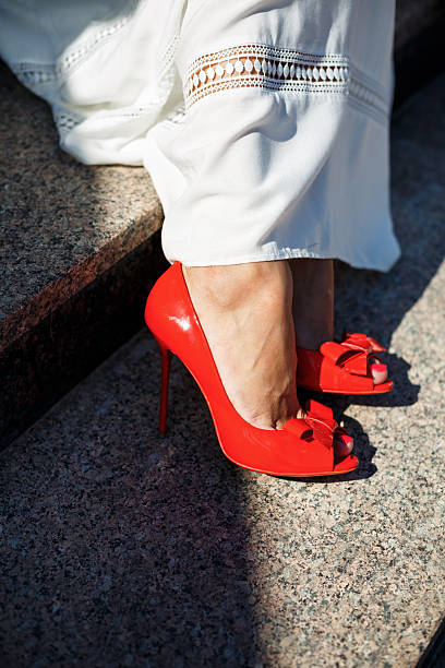 Closeup of Female foot with red stiletto heels shoe on white background