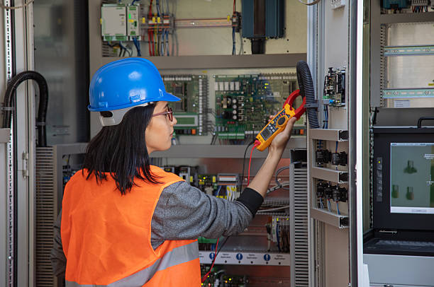 istock Female Electrical Engineer Using Digital Clamp Meter for Current Measurement in Industrial Power Control 2249707919