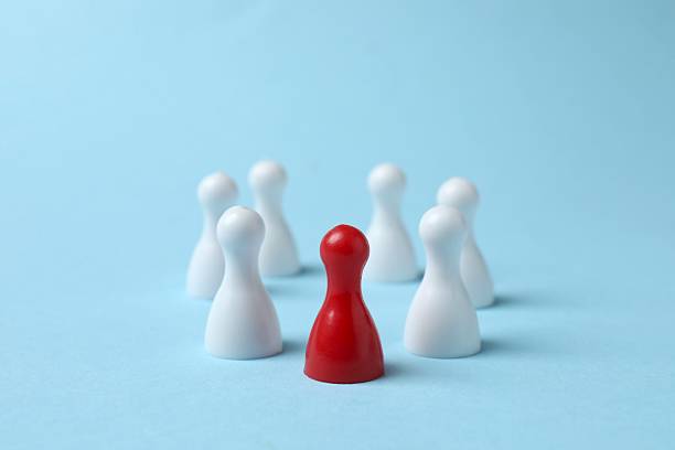 istock Group of colored pawns on a blue table. Concept of unity 2249708469