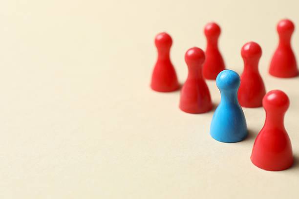 istock Unity concept. Group of color pawns on blue table. 2249710433