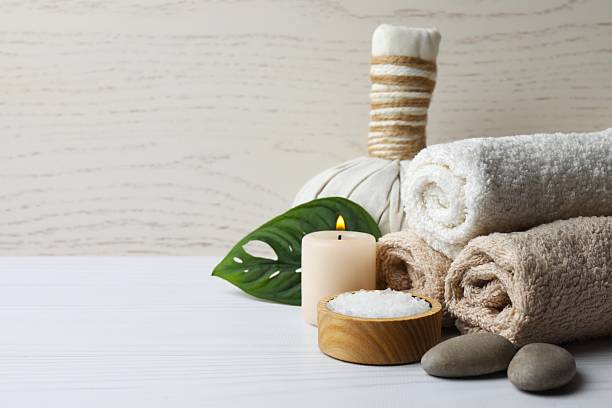 istock Spa concept. Spa bag, towel, candles and green leaf on the table 2249710550