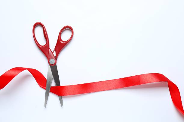 istock Beautiful red ribbon and scissors on white background, flat lay with space for text. Ceremonial tape cutting 2249710635
