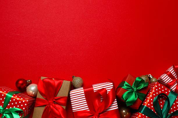 istock Beautiful gift boxes tied with bows and Christmas decorations on red background 2249710764