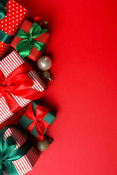 istock Vertical view of gift boxes nad Christmas decorations on red background 2249710765