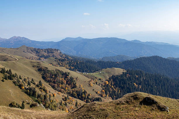 istock Mountain landscape with rocky foreground, grassy slope, forested hills and distant peaks under clear blue sky 2249711287