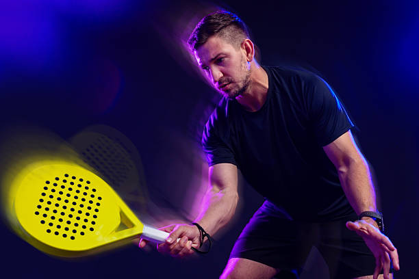 istock Man playing paddle tennis with dynamic movement and colorful lighting effects 2249712694