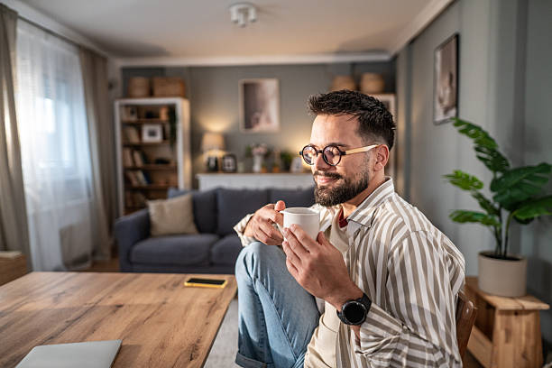 istock Young man relaxing at home drinking coffee 2249713260