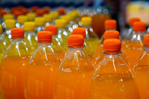 istock Rows of Refreshing Orange Bottled Drinks for Sale 2249713765