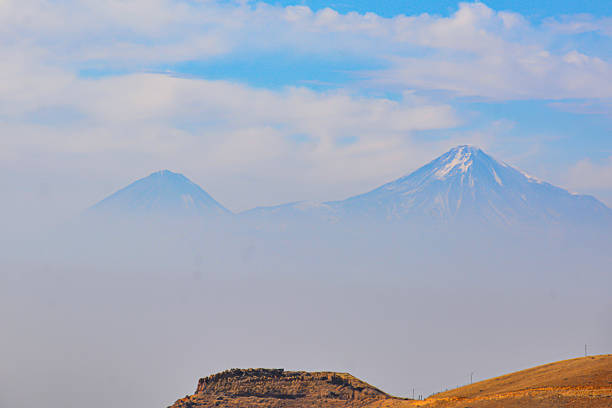 Mountain in the clouds. Beautiful mountain. Beautiful natural landscape with fields and mountains. Cloudy sky and mountain peak