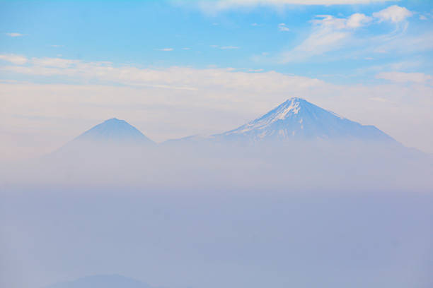 Mountain in the clouds. Beautiful mountain. Beautiful natural landscape with fields and mountains. Cloudy sky and mountain peak