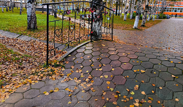 istock Small pedestrian bridge with many wedding locks and heart shaped railings in a park with autumn leaves, suitable for a romantic or seasonal concept 2249714036