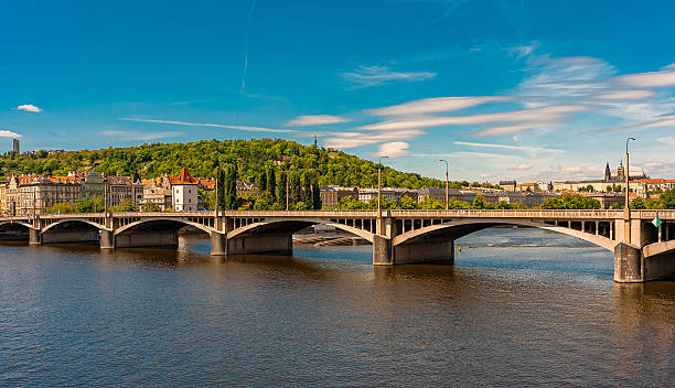 istock Jirasek Bridge. Modern bridge spanning river with historic city backdrop. 2249718330