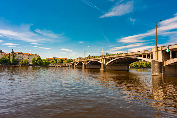 Jirasek Bridge. Modern bridge spanning river with historic city backdrop.