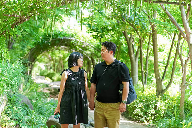 istock A man and woman are walking through a forest, holding hands 2249719085