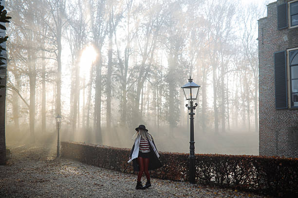 Young woman portrait outdoors in the woods with smoke bombs; Europe.