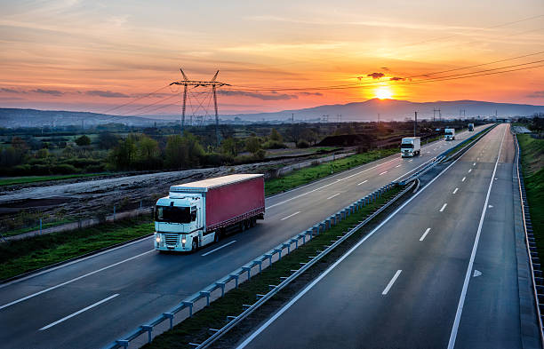 istock White Trucks with red containers on highway 2249721735