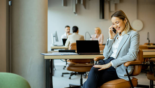 istock Business woman talking on phone in modern office setting during daytime 2249724666