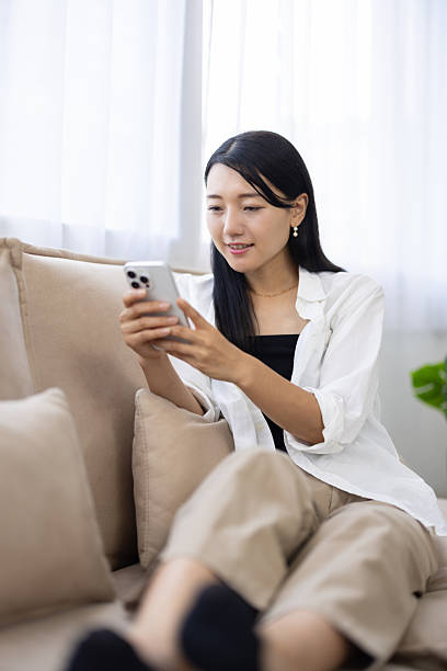 istock Woman Relaxing on Sofa Using Smartphone 2249725988