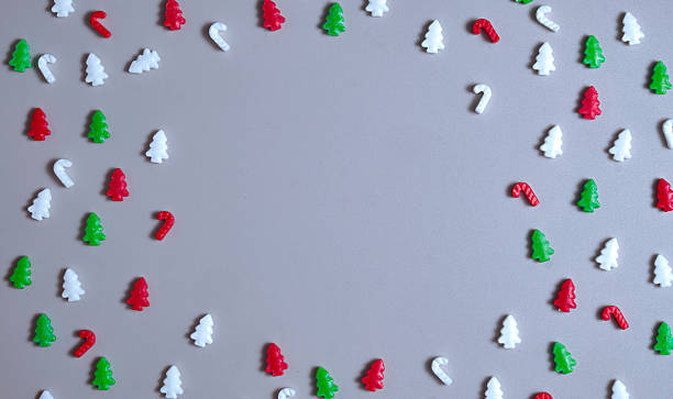 istock Christmas frame, candy shapes arranged as a festive border on a gray background. Gentle, childlike holiday layout perfect for overlays, cards, crafts, seasonal visuals. Copy space. Flat lay, top view 2249726812
