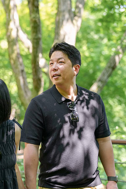 istock A man wearing sunglasses and a black shirt stands in a park 2249727219