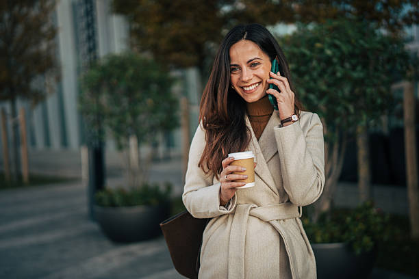 istock Woman smiling having coffee while talking on phone 2249727832