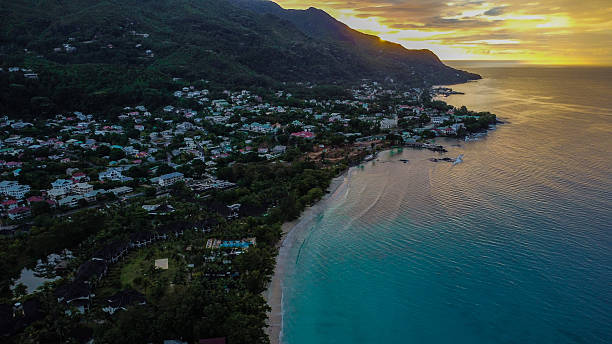 istock Golden Hour: Tropical Coastal Town, Sandy Beach, and Turquoise Water at Sunset 2249730210