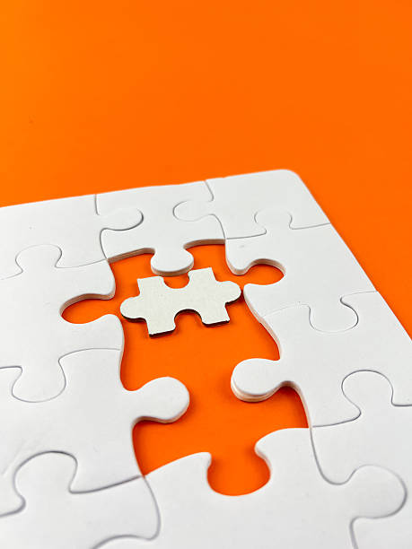 istock A conceptual puzzle photography with interlocking white puzzle pieces, some connected and some isolated, set against a vibrant yellow backdrop. 2249731786