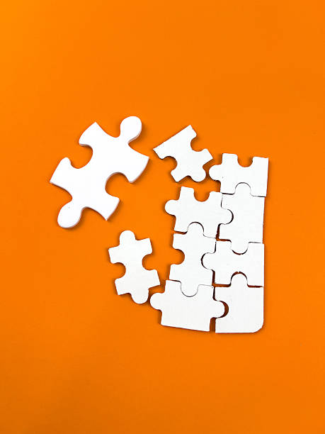 istock A conceptual puzzle photography with interlocking white puzzle pieces, some connected and some isolated, set against a vibrant yellow backdrop. 2249731851