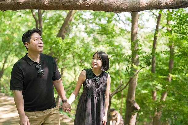 istock A man and woman are walking in a forest, holding hands 2249732573