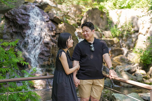 istock A man and woman are standing on a bridge overlooking a waterfall 2249733589