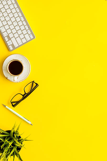 istock Home office workspace with computer keyboard and cup of coffee on yellow background, top view. Education online. Tabletop of freelancer 2249734791