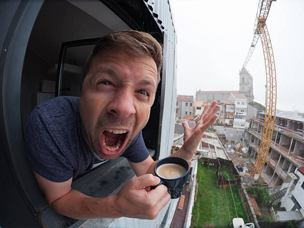 Angry man looking out the window with coffee. High quality photo