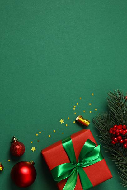 istock Beautiful gift box tied with bow and Christmas decorations on green background 2249735079