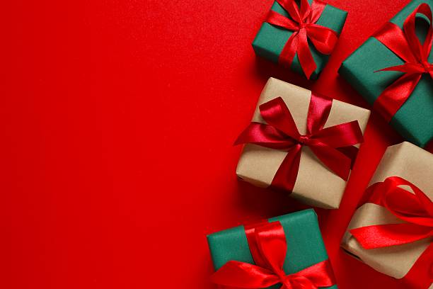 istock Beautiful gift boxes tied with bows on color red background 2249735456