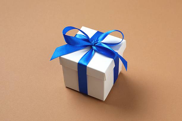 istock Beautiful gift box tied with blue bow on beige background 2249735485