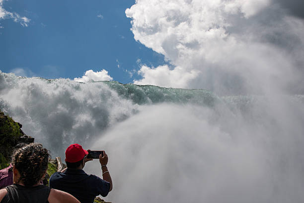 Niagara Falls, NEw York, USA - 1 August 2023: Visitors admire the breathtaking Niagara Falls, enjoying the spray and scenery.