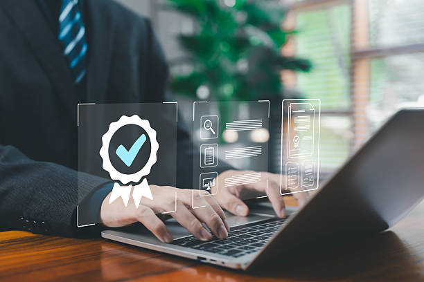 istock A business professional typing on a laptop with digital quality certification icons, representing compliance, approval, document verification, corporate standards, audit procedures, and modern quality 2249740550