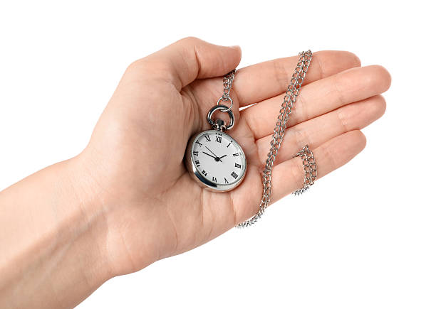 Antique pocket watch from 1917 with an old U.S silver dollar on black background.