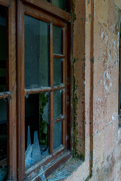 istock Broken window in old abandoned building exterior 2249740942