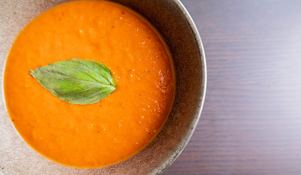 istock creamy roasted tomato and red pepper soup with fresh basil in black bowl 2249741461