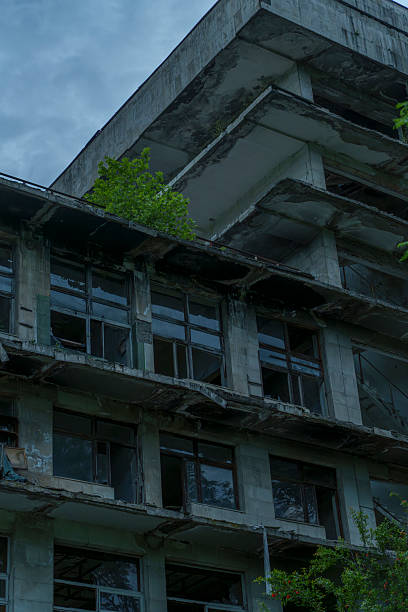 istock Broken concrete balconies and windows of abandoned hotel against sky 2249741660