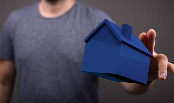 istock A person is holding a blue house model, representing homeownersh 2249742396