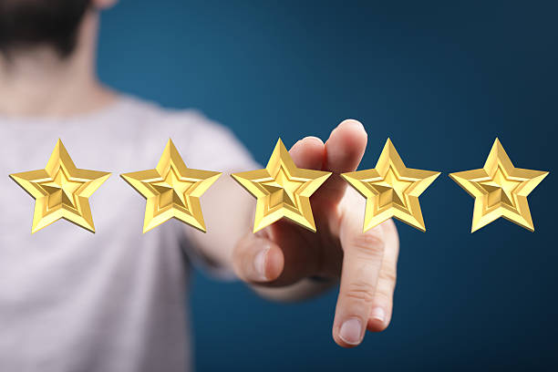 istock A person's hand gestures towards five golden stars, representing 2249742458