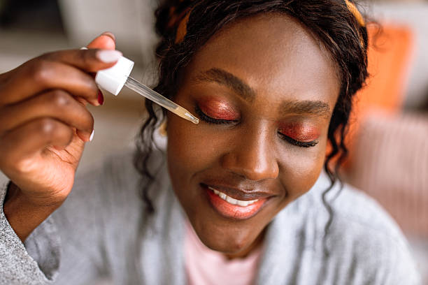 istock Young Woman Applying Facial Serum While Sitting On Bed. 2249744274