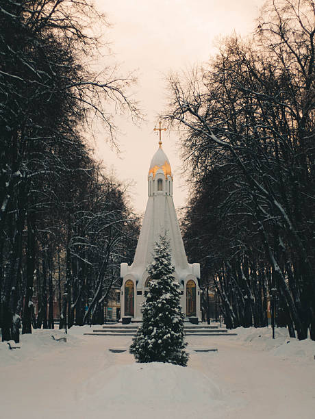 A calm and serene winter landscape depicts a charming church alongside a snowcovered pathway, evoking deep tranquility