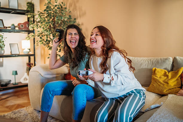 istock Friends laughing playing video games on couch 2249745721