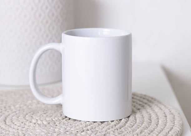 istock White blank coffee mug 11oz on beige placemat Close up. Boho mock up, copy space 2249746725