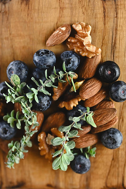 Blueberries almonds walnuts and thyme on wood