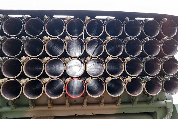 A military rocket launcher is displayed with numerous launch tubes visible. The arrangement highlights the cylindrical tubes used for launching rockets. It is a clear day, outdoors.